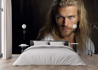 Close-up portrait of a very handsome man with gray eyes, long blond hair, and a short blond beard, wearing a white shirt - copy space, isolated, dark background Wall mural