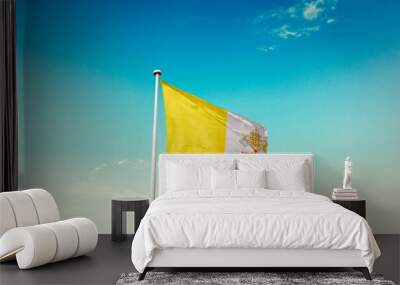 Waving Flag of Vatican City in Blue Sky. The symbol of the state on wavy cotton fabric. Wall mural