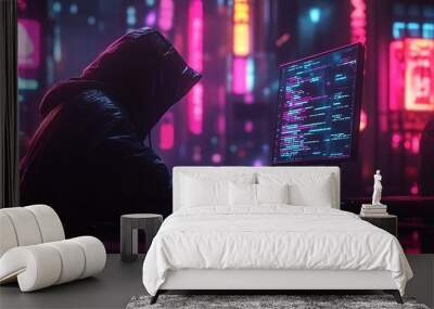 A hacker types on his computer, neon city lights reflecting off the screen and casting a glow around him. Wall mural