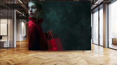 Black friday sale concept of young woman holding shopping bag on dark background with copy space fashion style.  Wall mural