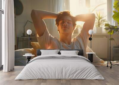 handsome young man stretching in bed during morning time at home.  Wall mural