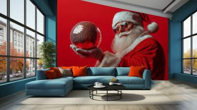 santa in stylish eyeglasses holding party ball. red solid one color background. Wall mural