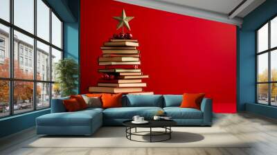 Christmas concept background. Books in the form of a christmas tree with christmas balls and red star over christmas lights and snowflakes Wall mural