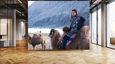 A beautiful Asian tourist woman riding camel in the Hunder desert , Ladakh India Wall mural