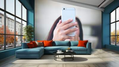 A girl using and looking smart phone in modern room Wall mural