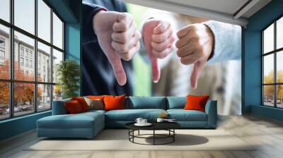 A group of people making thumb down hands sign in circle Wall mural