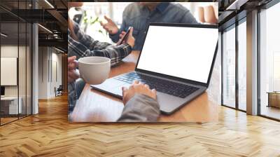 A woman using and touching on mockup laptop computer touchpad with colleagues in meeting Wall mural