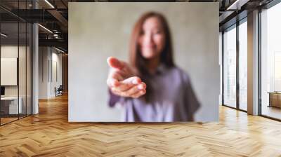 Blurred image of a young woman with reaching hand or giving hand to someone Wall mural