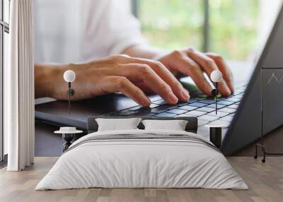 Closeup image of a woman hands working and typing on laptop computer keyboard Wall mural