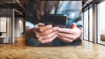 Closeup image of a woman holding , using and looking at mobile phone Wall mural