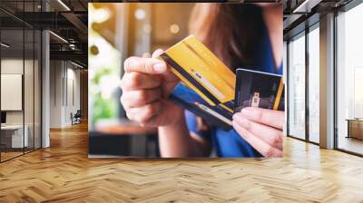 Closeup image of a woman holding and choosing credit card to use Wall mural