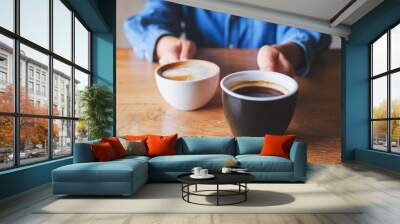 Closeup image of a woman holding and serving two cups of hot coffee Wall mural