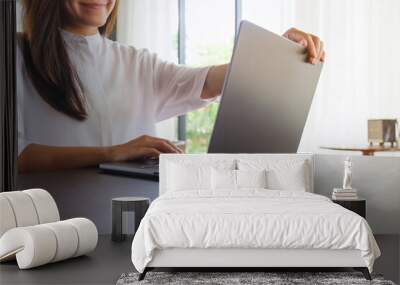 Closeup image of a woman opening or closing laptop computer, getting ready for work Wall mural