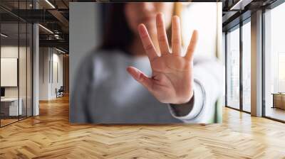 Closeup image of a woman outstretched hand and showing stop hand sign Wall mural