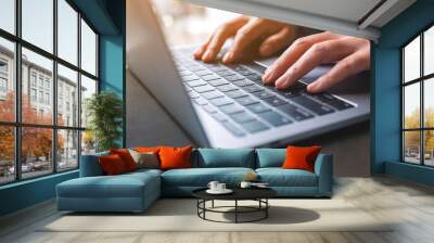 Closeup image of a woman working and typing on laptop computer on the table Wall mural