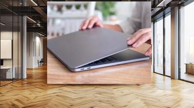 Closeup image of hands close and open a laptop computer on table after finished using it Wall mural