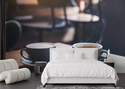 Closeup image of two blue cups of hot latte coffee and Americano coffee on vintage wooden table in cafe Wall mural