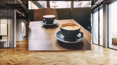 Closeup image of two blue cups of hot latte coffee on wooden table in cafe Wall mural