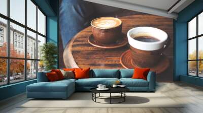 Closeup image of two cups of hot latte coffee and black coffee on vintage wooden table in cafe Wall mural