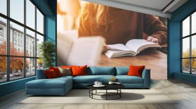 Group of people sitting and enjoyed reading books together on wooden table Wall mural