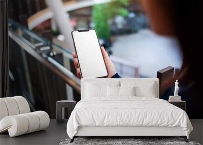 Mockup image of a woman holding mobile phone with blank white screen indoors Wall mural