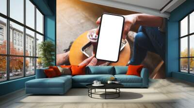 Mockup image of a woman showing a mobile phone with blank desktop screen to a man Wall mural