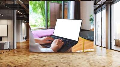 Mockup image of a woman using and typing on computer laptop with blank desktop screen at home Wall mural