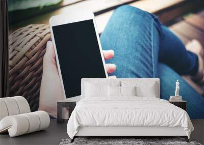 Mockup image of hand holding white mobile phone with blank black screen on thigh  Wall mural