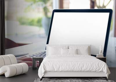 mockup image of hand using laptop with blank white screen on vintage wooden table in cafe Wall mural