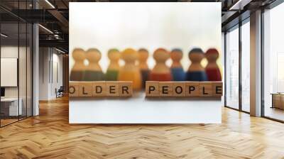 OLDER PEOPLE word on wooden blocks with a group of different people in the background Wall mural