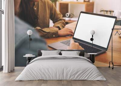 People using and looking at mockup laptop computer on wooden table together Wall mural