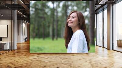 Portrait image of a beautiful asian woman standing in the park Wall mural