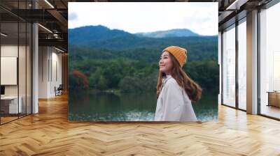 Portrait image of a young asian woman with a beautiful greenery mountains and the lake in background Wall mural