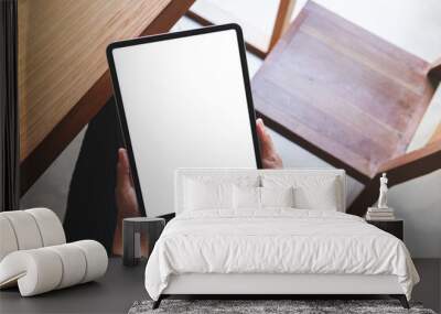 Top view mockup image of a woman holding digital tablet with blank white desktop screen in cafe Wall mural