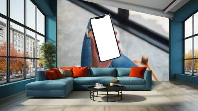 Top view mockup image of a woman holding mobile phone with blank white screen Wall mural