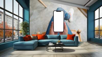 Top view mockup image of a woman holding mobile phone with blank white screen Wall mural