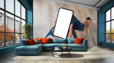 Top view mockup image of a woman holding mobile phone with blank white screen Wall mural