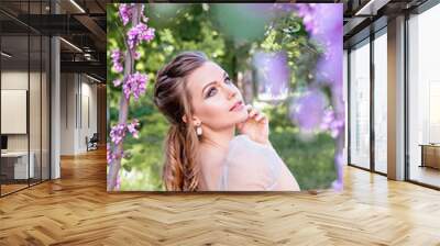 I love spring and summer! Incredibly beautiful girl walks in the flowered garden. Female beauty complements the natural beauty of nature. Wall mural