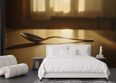 64. A perspective view of a lone spoon on a plain table, with natural light adding depth and simplicity Wall mural