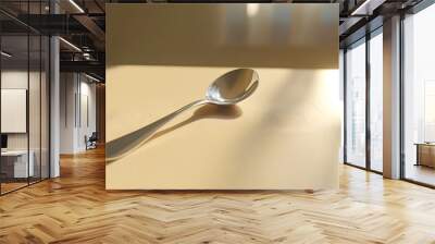 64. A perspective view of a lone spoon on a plain table, with natural light adding depth and simplicity Wall mural