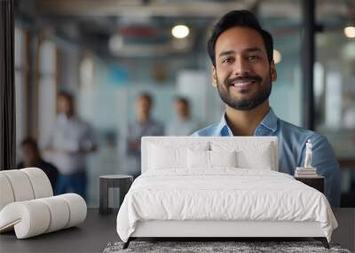 Portrait of a handsome smiling asian indian businessman boss standing in his modern business company office. Wall mural