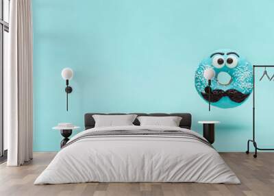 Blue glazed donut with mustache. Flying blue doughnut with funny face with mustache over blue background. Copy space for text. Masculinity or father day concept. Banner Wall mural