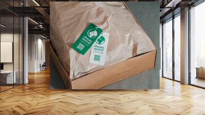 Carbon neutral product in craft corrugated box with label Climate neutral. Carbon neutral label concept in apparel, fashion, logistics indusrty and ethical consumption. Increasing awareness for Wall mural