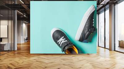 pair of new kids or adult sneakers on blue background, top view. Flat lay gray and yellow or mustard color sneakers shoes on colorful bright blue background with copy space for text or design Wall mural