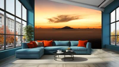 
A majestic sunrise over the mountains, a fine expanse of mist, an orange morning sky Wall mural