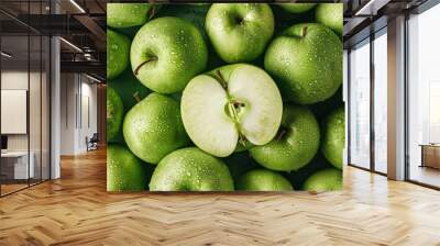 A pile of fresh green apples, one apple is cut in half. Wall mural