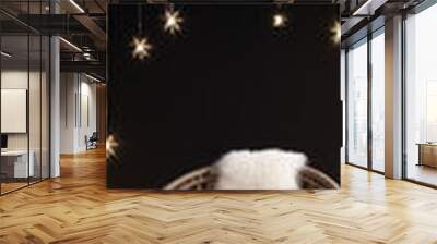 A cozy wicker chair with a white fur throw and glowing star lights create a magical and romantic winter scene. 
 Wall mural