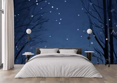 Silhouettes of trees against a blue sky with falling snow, perfect for winter and holiday designs. 
 Wall mural