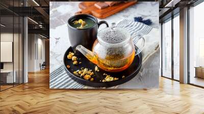 Hot tea in glass cup with steam and lemon .tea leaves and mint herb on wood background , cup of Asian herbal tea Wall mural