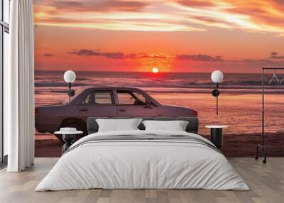 car on the beach, car on the beach sunset car parked on the beach with beautiful vibrant red sunset sky, summer road trip travel Wall mural